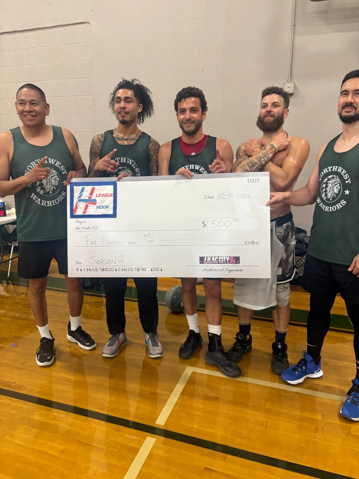 The Season 1 champions on the court at The Warehouse, holding the oversized League of Hoop prize check